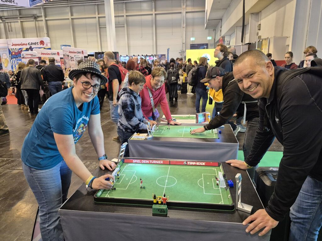 Ein Mann und eine Frau spielen "Tipp-Kick" bei der SPIEL 2025.