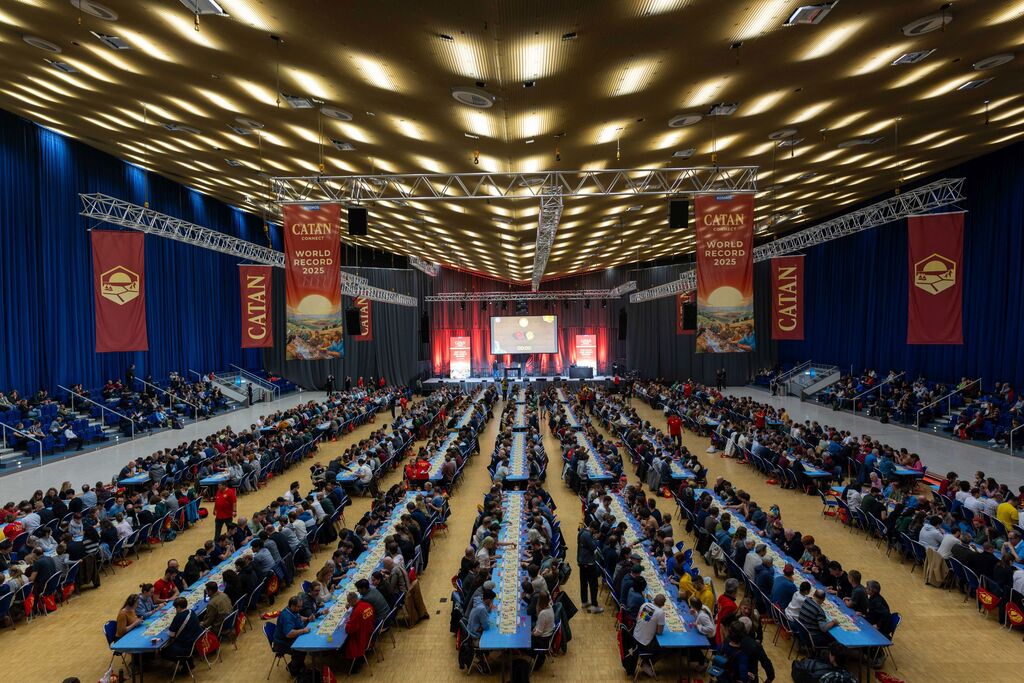 Ein Blick von oben in eine Halle voller Tische und Menschen.