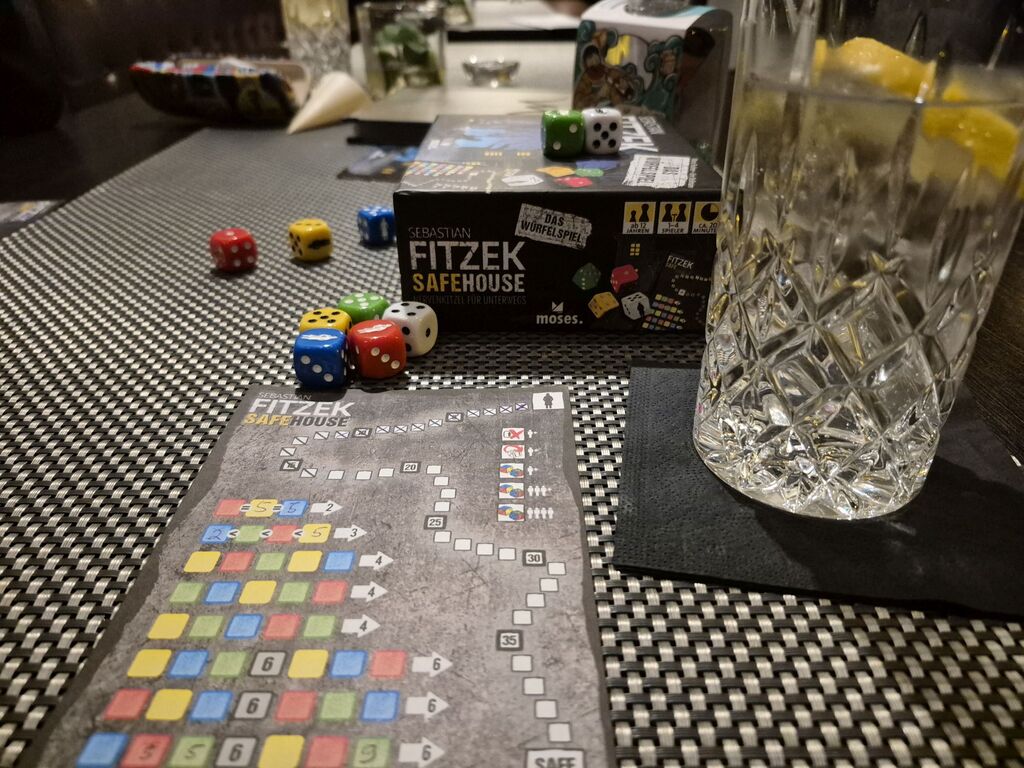Spielmaterial und ein Glas.
