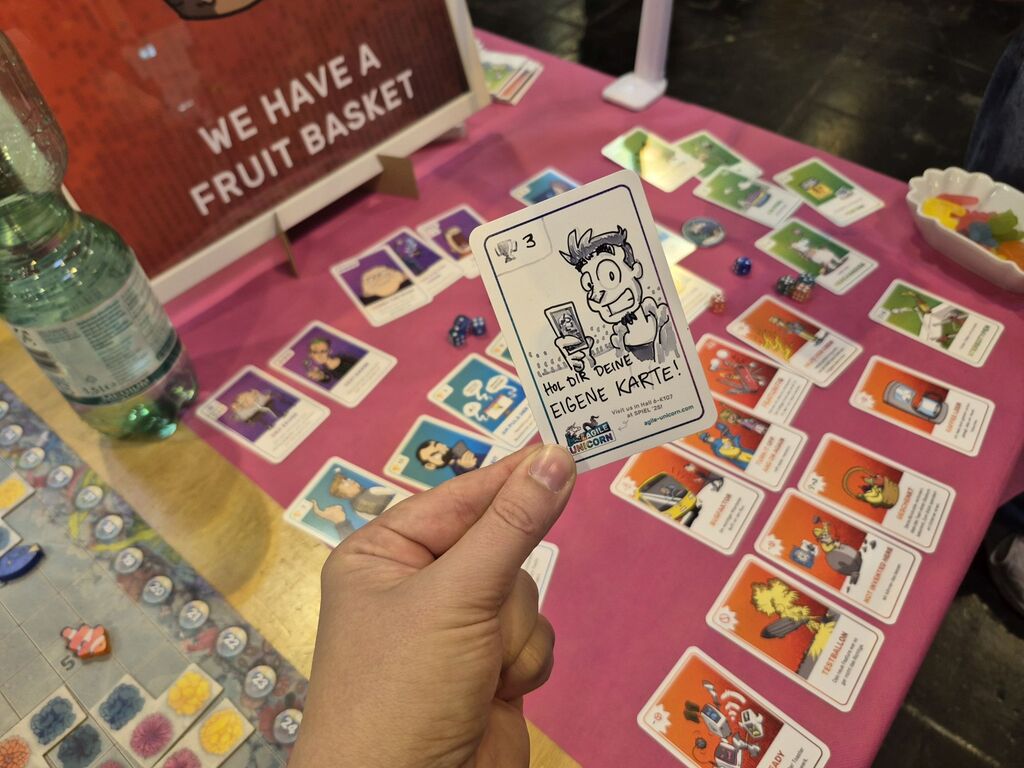 Eine Hand hält eine Karte über Spielmaterial.