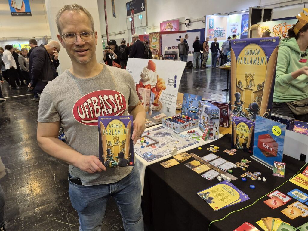 Ein Mann hält ein Spiel hoch.