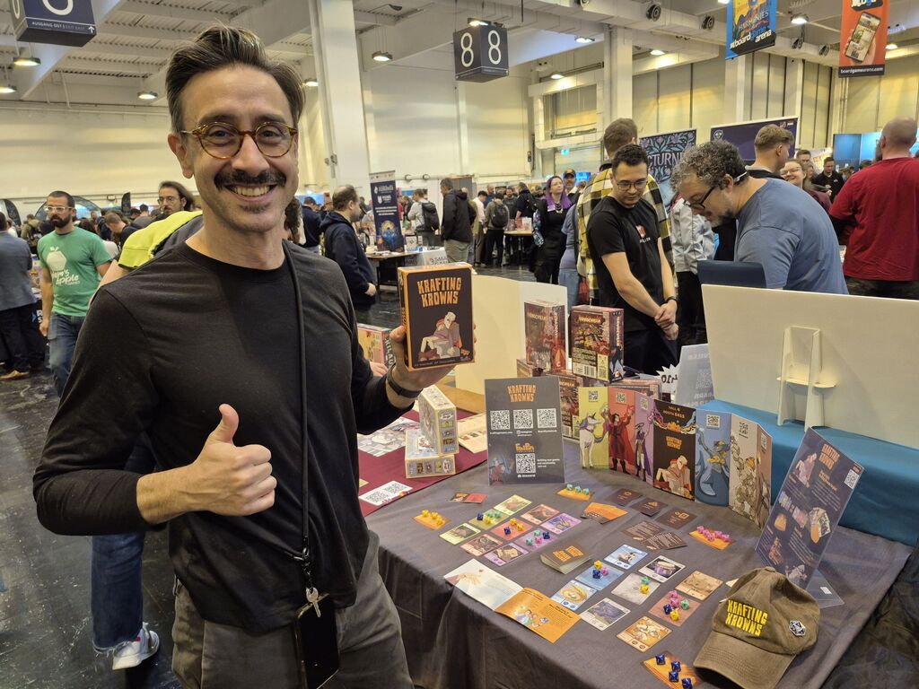 Ein Mann hält die Spielschachtel von "Krafting Krowns" hoch.