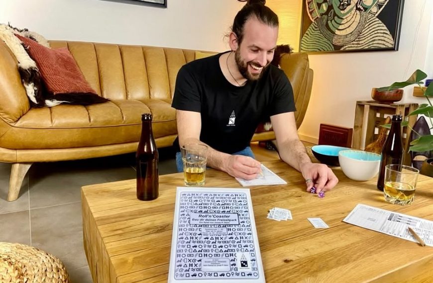 Ein Mann an einem Tisch mit Spielmaterial.