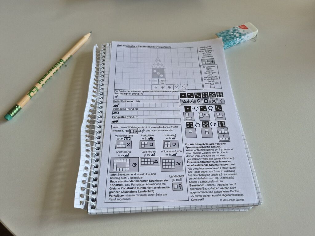 Ein Blatt vom Spielblock von "Roll'n'Coaster"; ein Radiergummi und ein Bleistift.