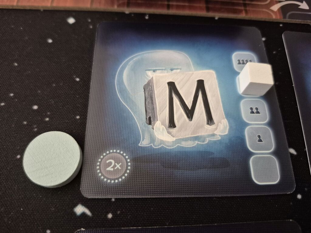 Zwei Marker liegen auf und neben einer Karte mit einem M.