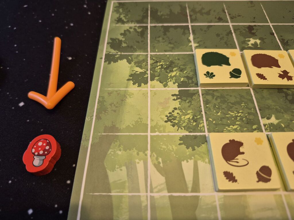Ein Pfeil zeigt auf einen Pilzmarker, der neben dem Spielertableau liegt.