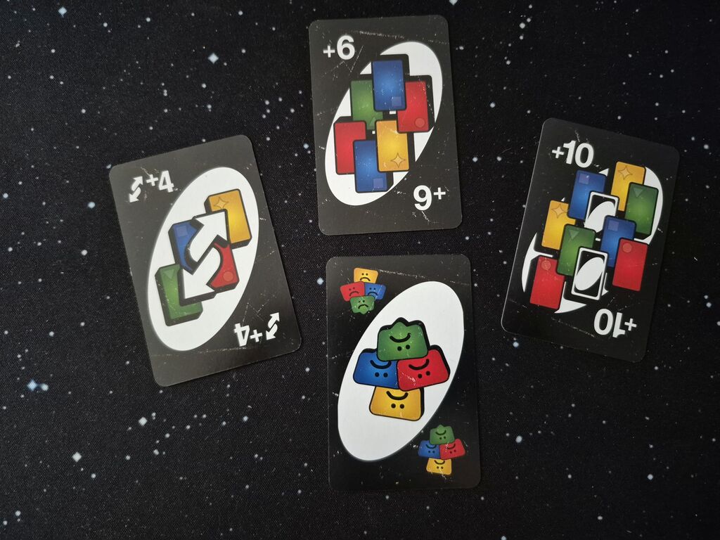 Vier bunte Karten mit Zahlen und Symbolen.