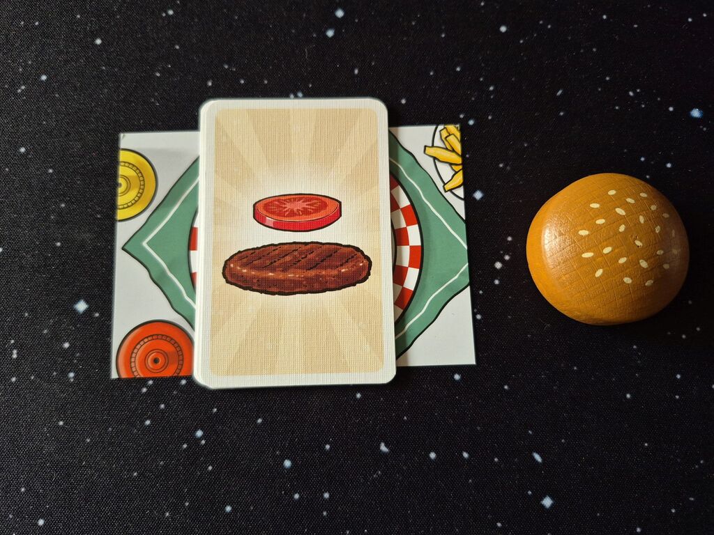 Ein Stapel Karten, daneben ein Burgerbrötchenoberteil aus Holz.