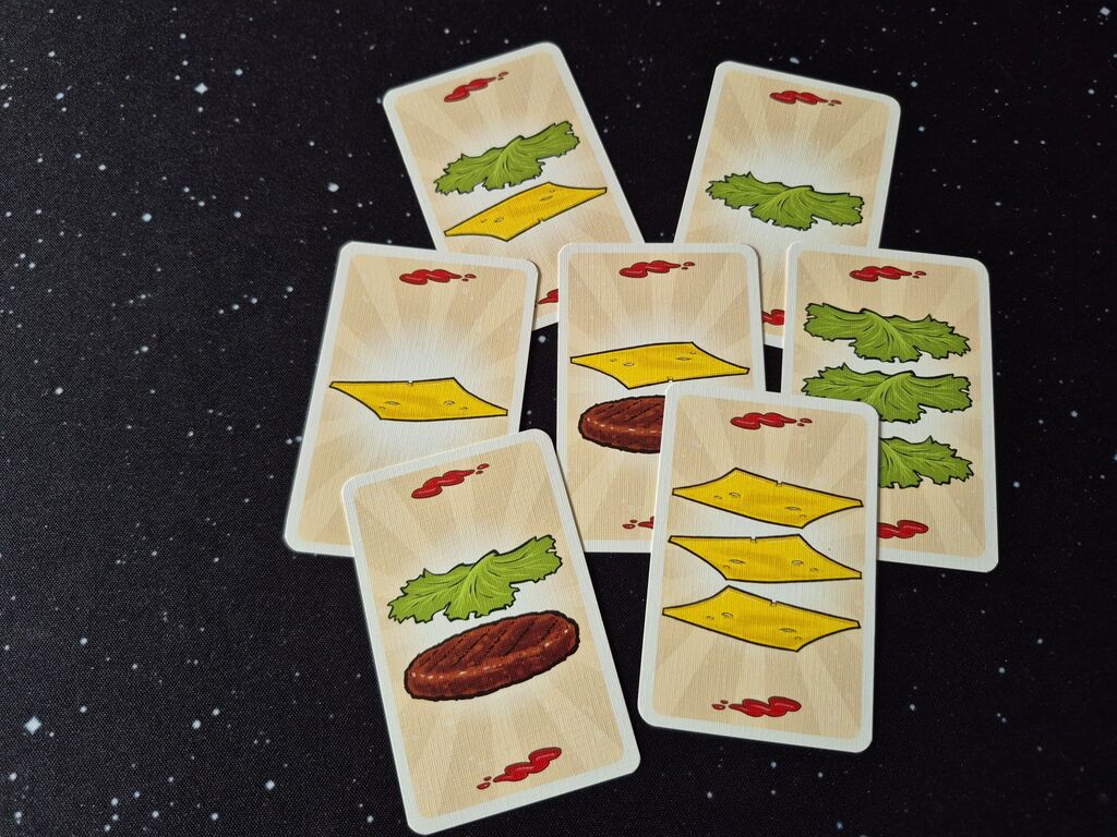 Karten mit Burgerzutaten und roten Flecken.