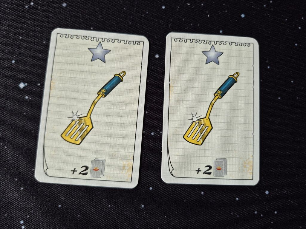 Zwei Karten mit einem silbernen Stern und einem Pfannenwender.