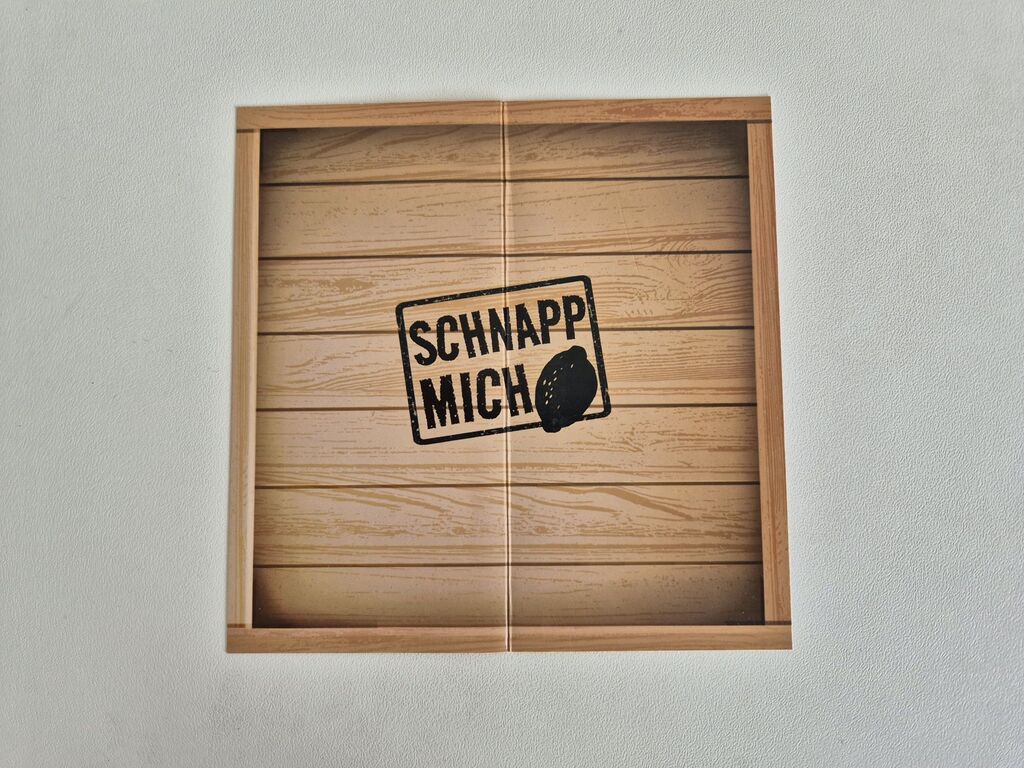 Eine Schachtel in Holzoptik mit dem Text "Schnapp mich".