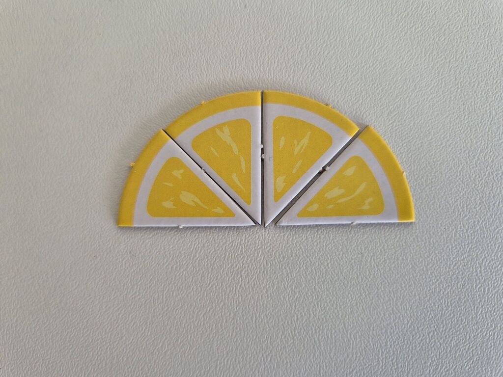 Vier Pappteile, die aneinandergelegt wie eine halbe Zitronenscheibe aussehen.