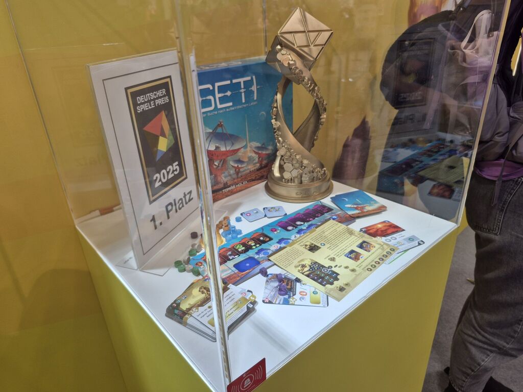 Eine Vitrine mit ienem goldenen Pokal und Spielmaterial von "Seti".