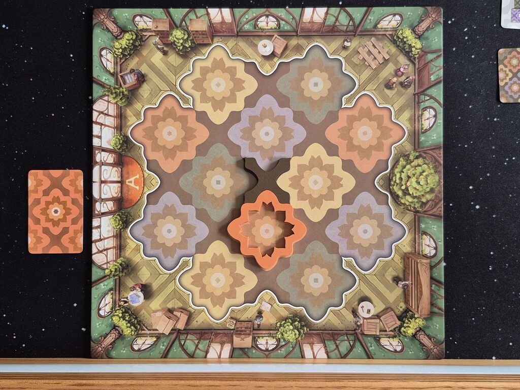Eine Karte liegt neben dem Spielplan, auf dem zwei Bodenteile liegen.