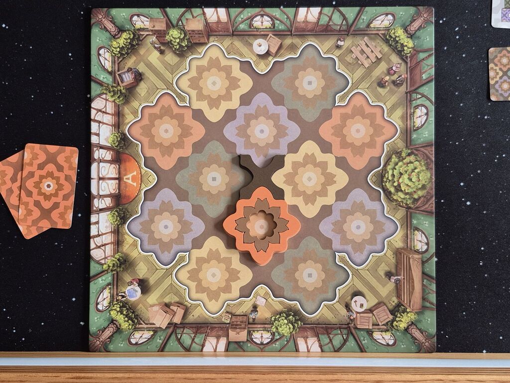 Zwei Karten neben dem Spielplan, darauf drei Bauteile.