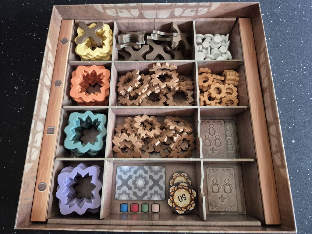 Das Innere der Spielschachtel von "Intarsia". In Fächern ist Spielmaterial sortiert.