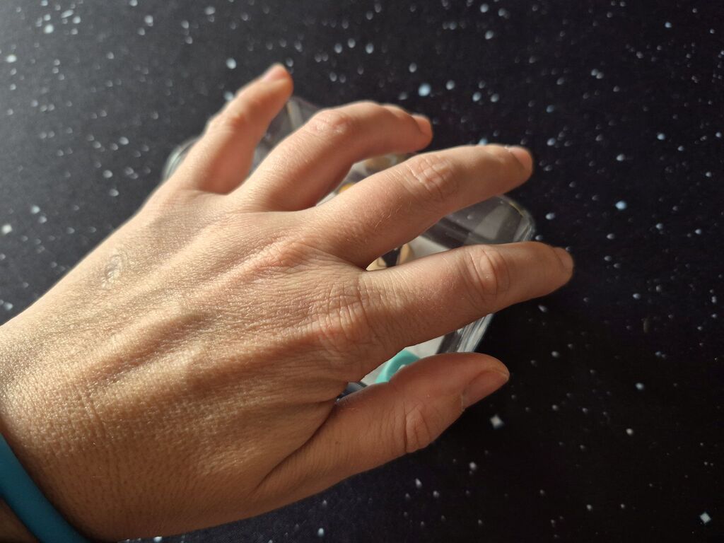 Eine Hand deckt die eben noch zu sehende Flasche mit Würfeln ab.