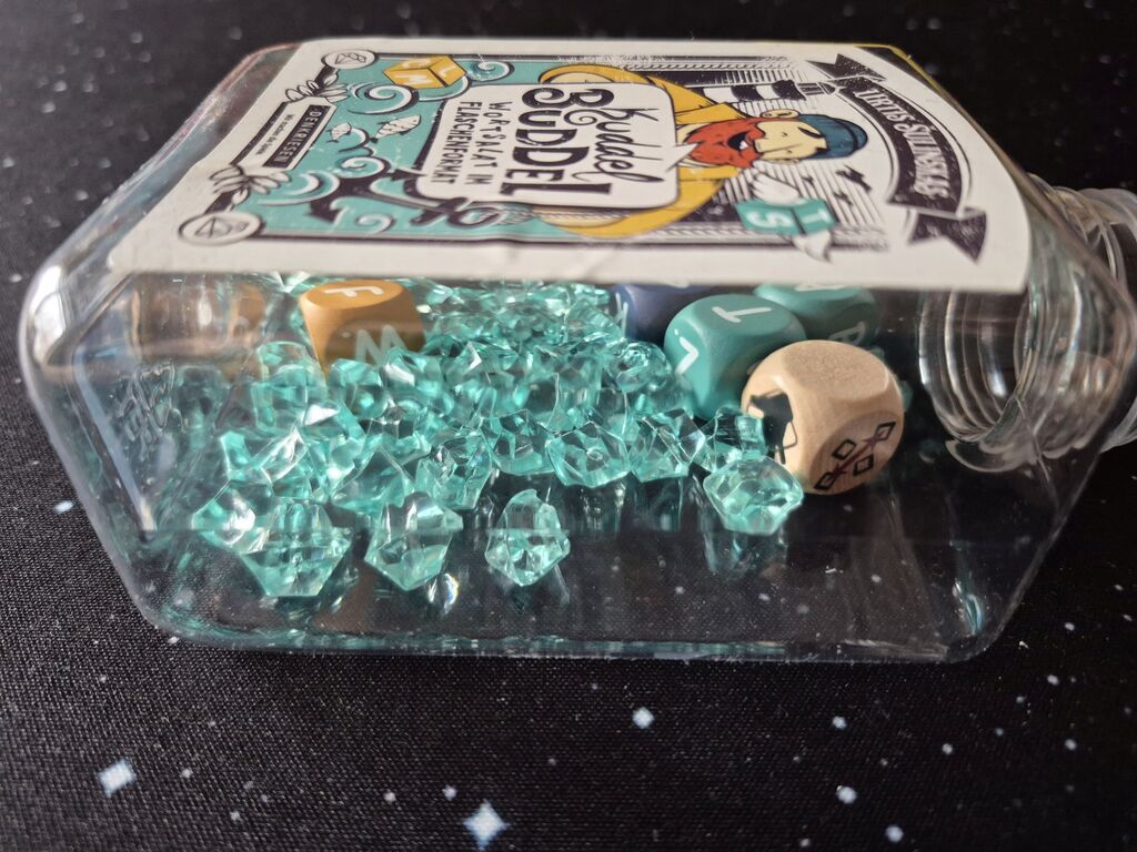 Eine Kunststoffflasche mit dem Spielmaterial von "Kuddel Buddel".