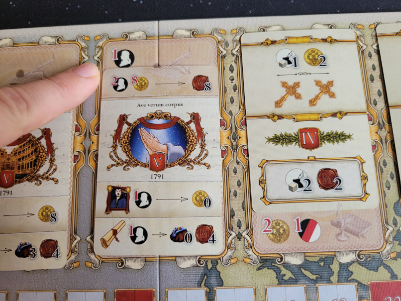 Ein Finger zegit auf Symbole auf dem Spielplan.