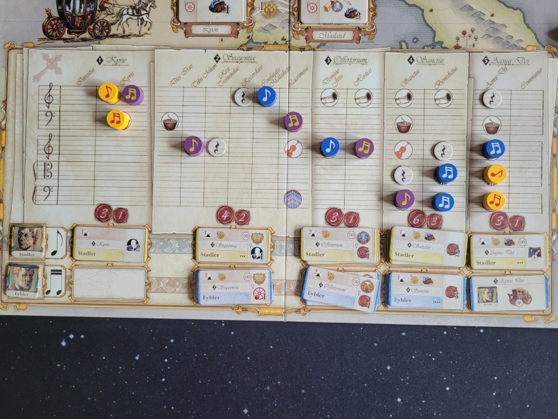 Marker in verschiedenen Farben liegen auf Notenlinien auf dem Spielplan von "Lacrimosa".