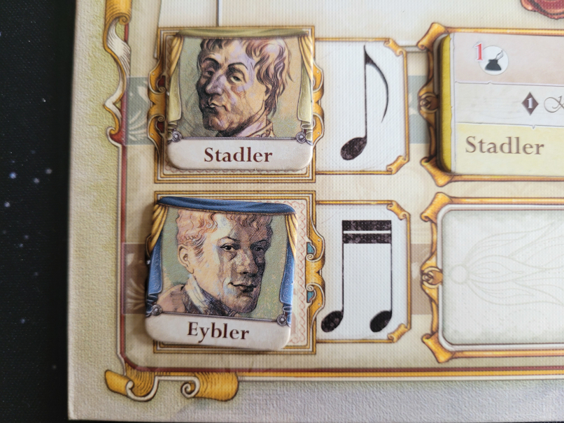 Plättchen auf dem Spielplan zeigen je einen Kopf und die Namen "Stadler" und "Eybler".
