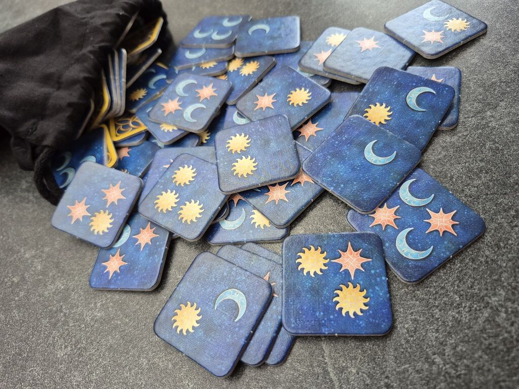 Aus einem schwarzen Beutel sind viele quadratische Plättchen gefallen.