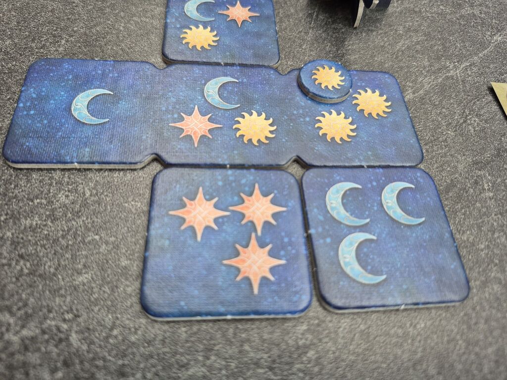 Plättchen mit insgesamt vier Sonnen, Monden und Sternen.