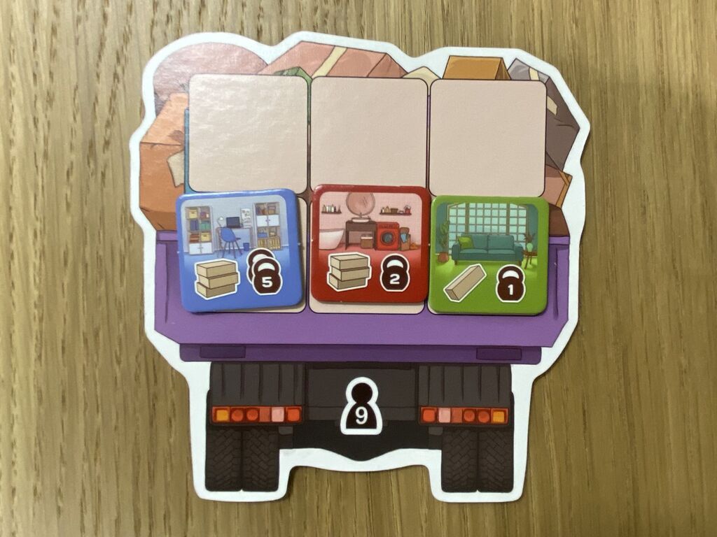 Ein Plättchen in Form eines LKW, auf dem Platz für sechs Umzugskartons ist.