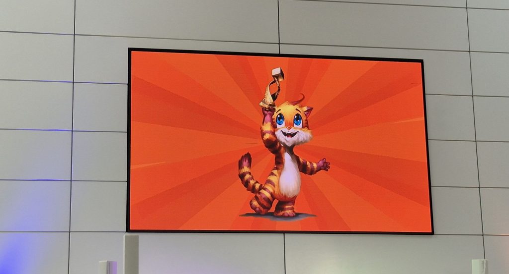 Auf einem Bildschirm hält eine gezeichnete Katze einen Pokal hoch.