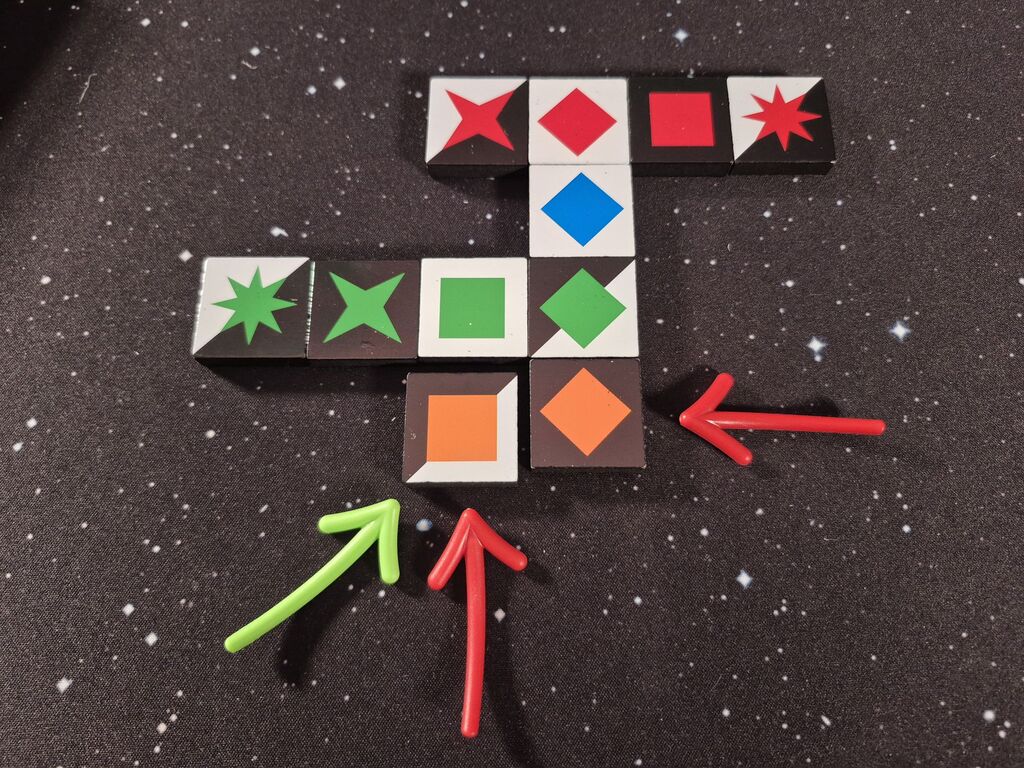 Spielsteine in Reihen und Spalten, auf einige zeigen Pfeile.