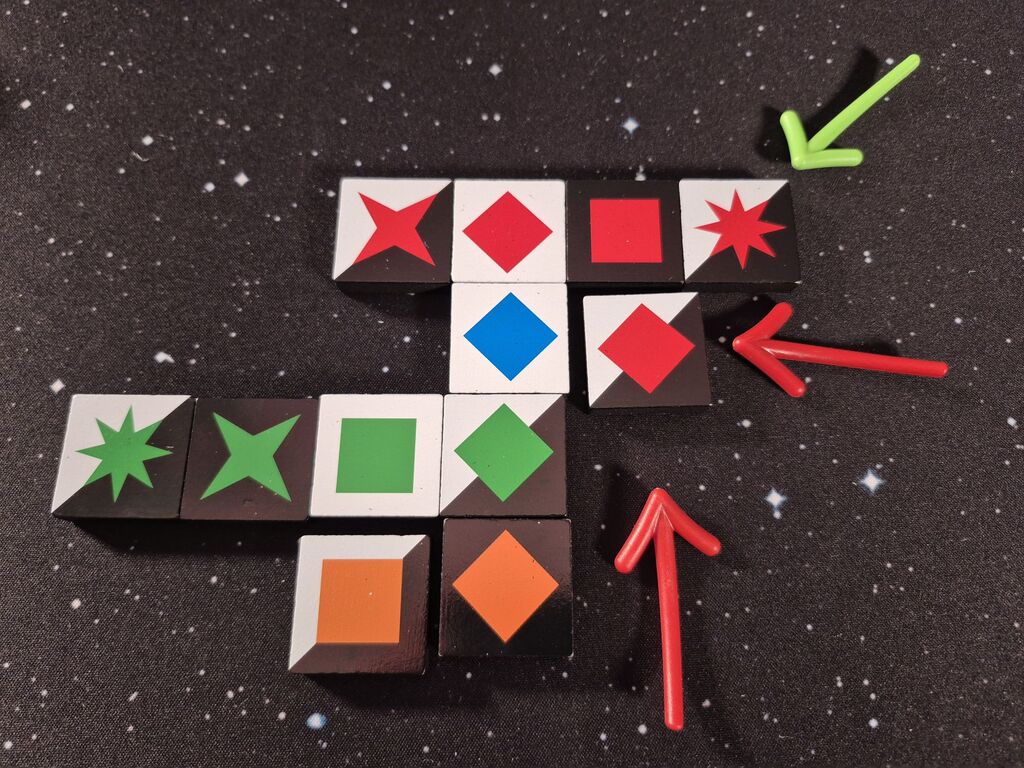 Mehr Spielsteine aus "Qwirkle Flex" in Reihen und Spalten, auf einige zeigen Pfeile.