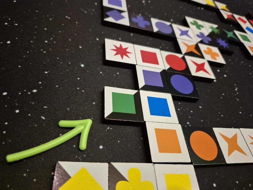 Ein Pfeil zeigt auf Spielsteine.