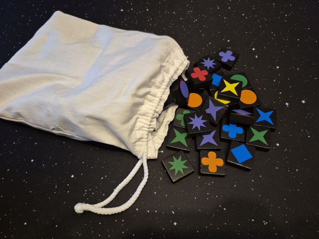 Spielsteine aus "Qwirkle" sind teilweise aus einem Beutel gekippt.