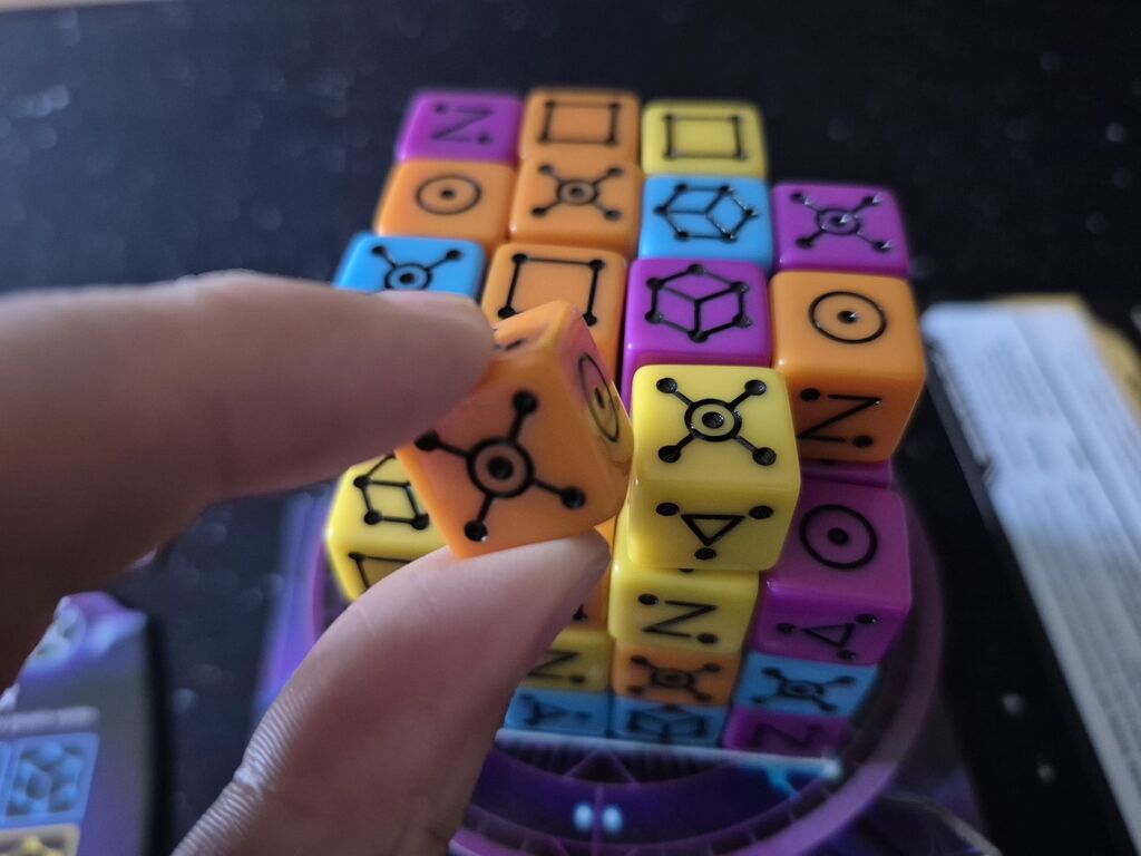 Eine Hand nimmt einem Würfel aus einem Würfelstapel.