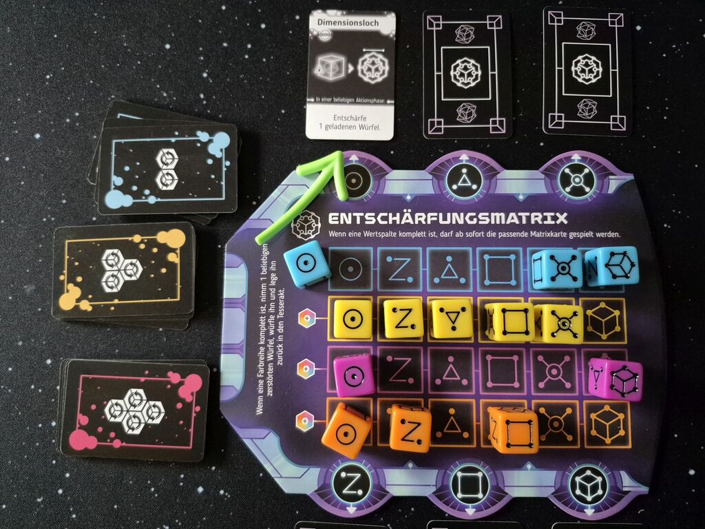 Spielmaterial mit Würfeln und Karten mit Symbolen.