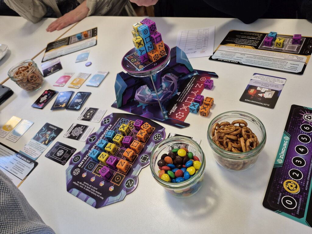 Spielmaterial und kleine Gläser mit Smarties und Salzbrezeln.