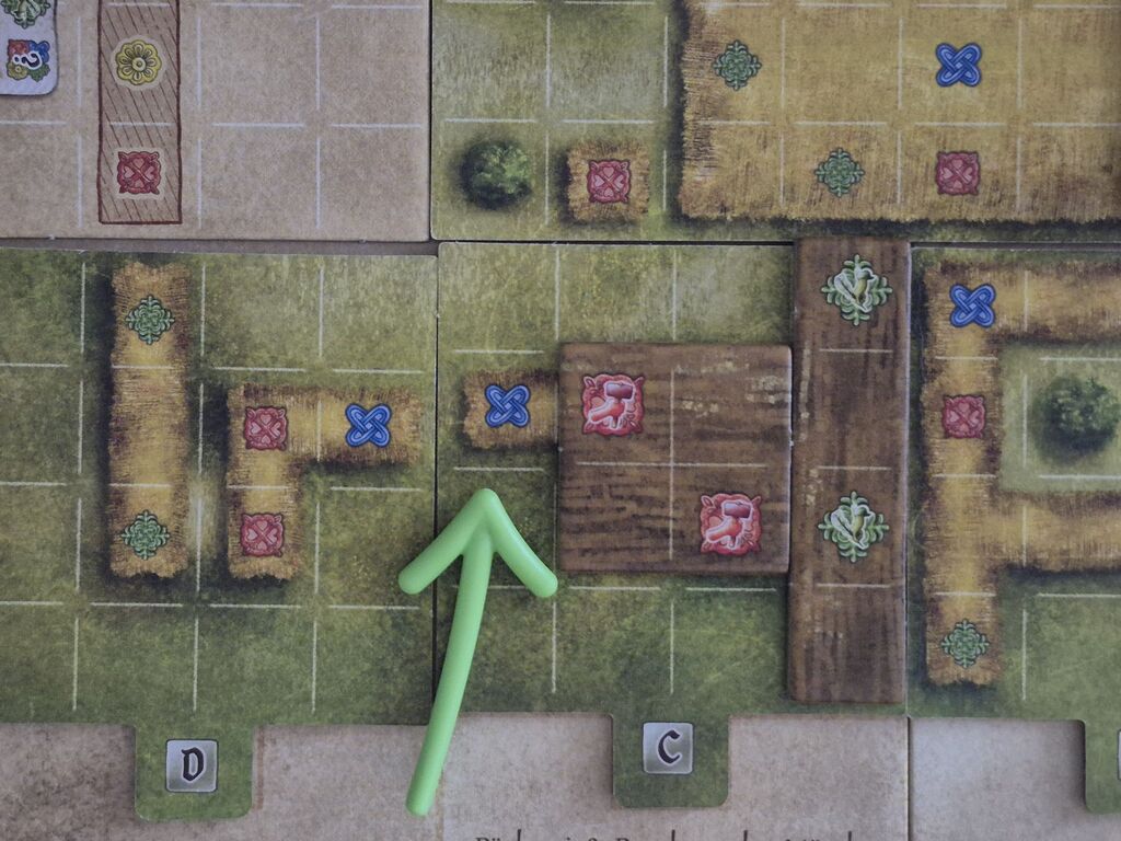 Ein Pfeil zeigt auf ein Feld auf dem Spielplan.