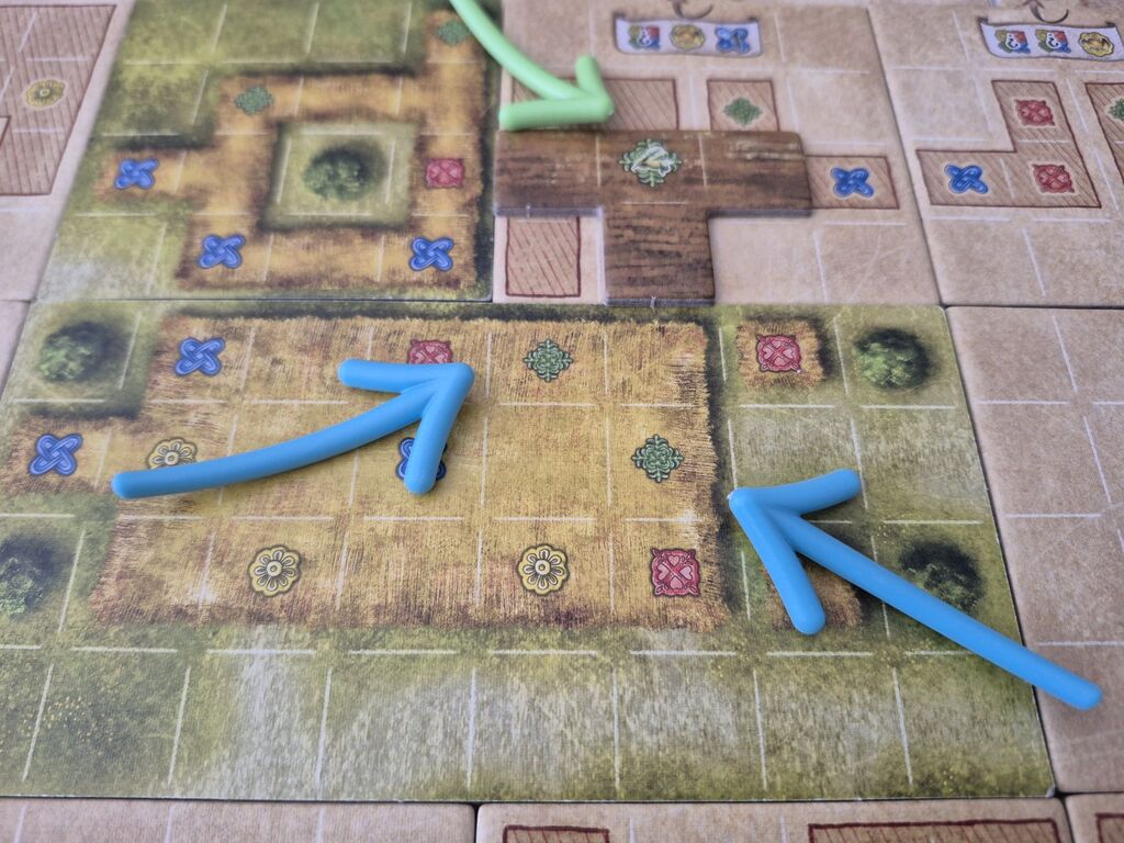 Pfeile zeigen auf Spielmaterial von "Campus Galli".