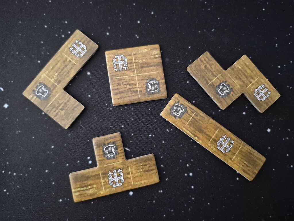 Fünf Polyominos mit einem weißen und einem schwarzen Symbol.