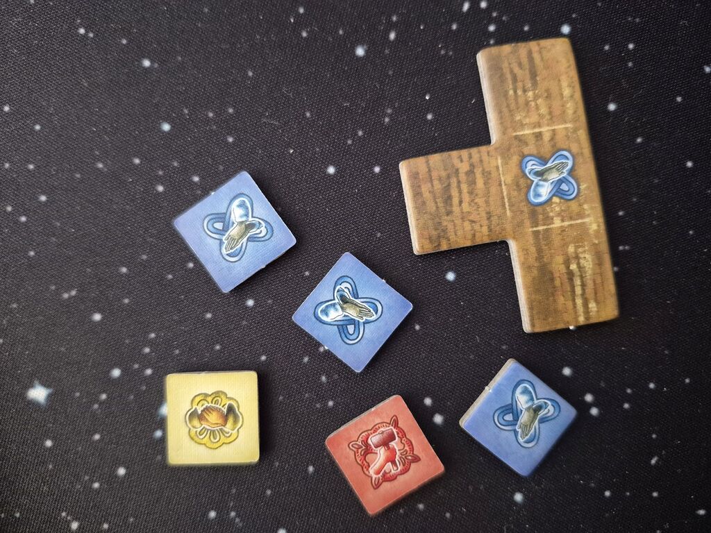 Fünf Plaketten-Plättchen neben einem Bauteil aus "Campus Galli".