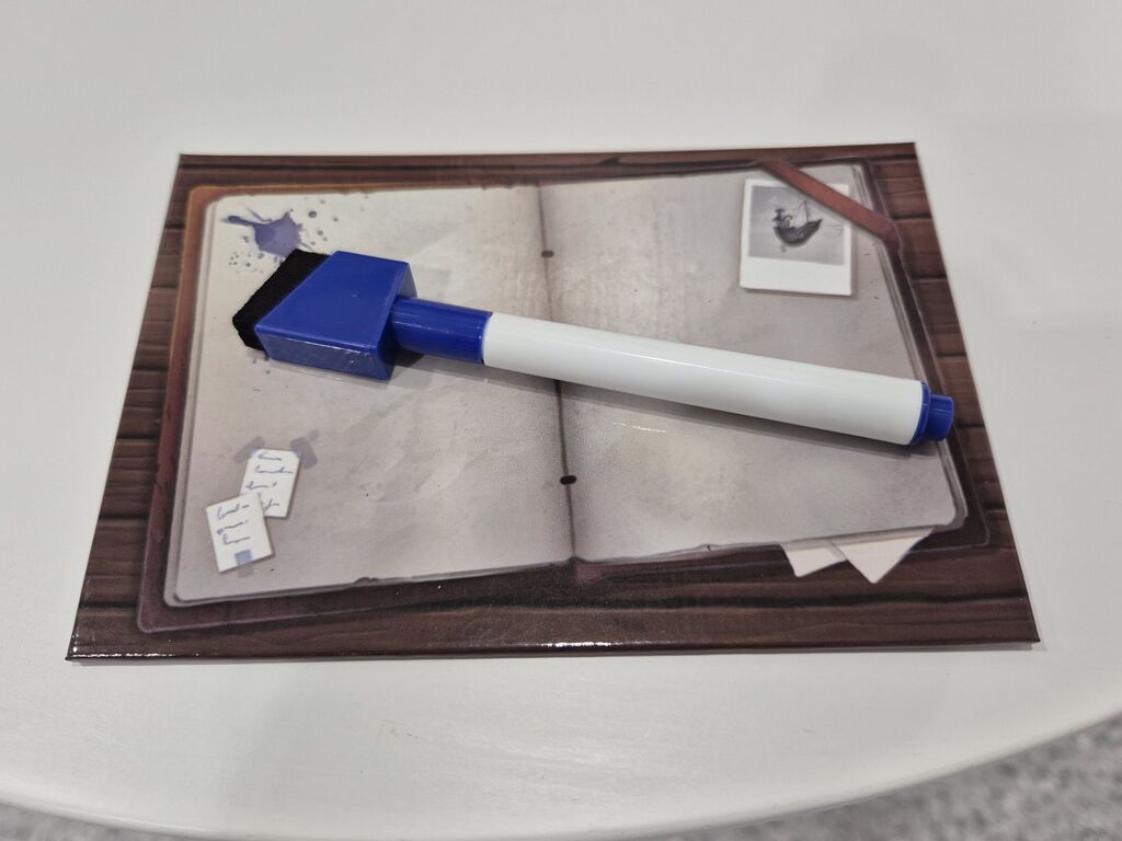 Ein Stift liegt auf einem Tableau aus "Der Abenteuer Club auf großer Reise".