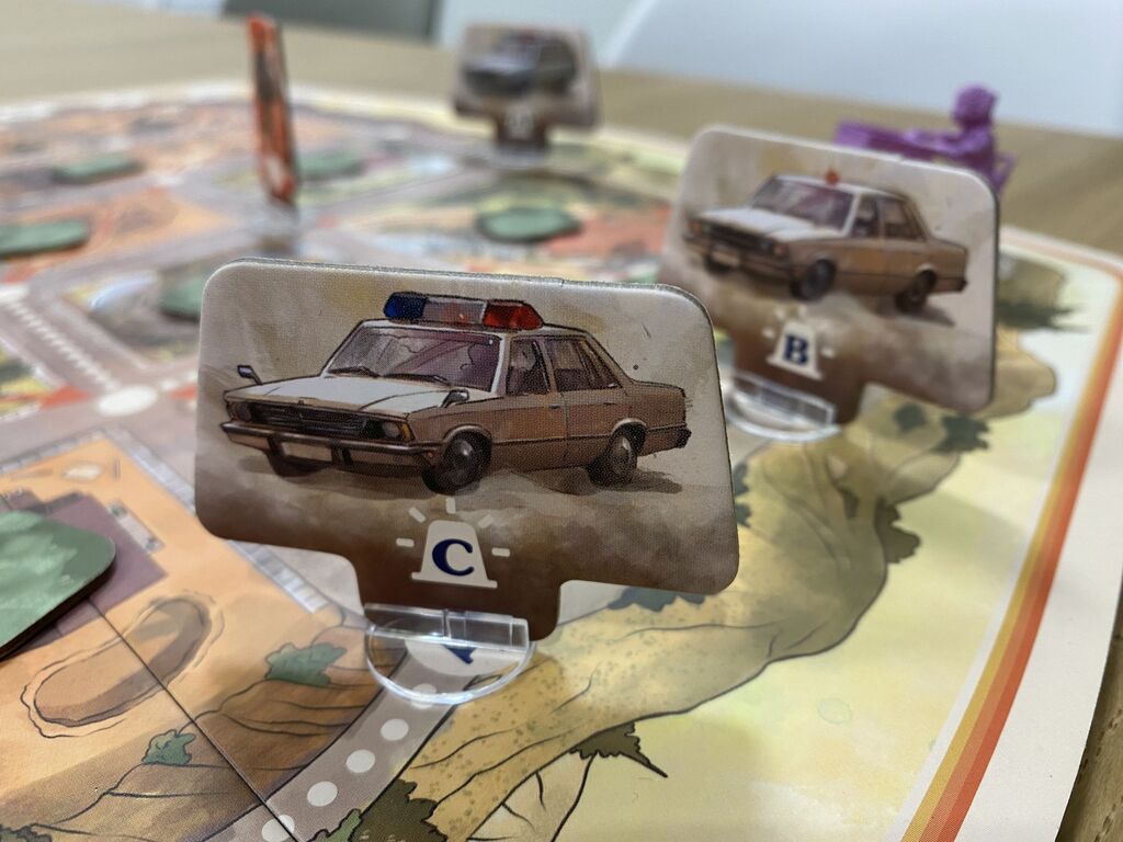 Zwei Spielfiguren zeigen alte Polizeiautos.