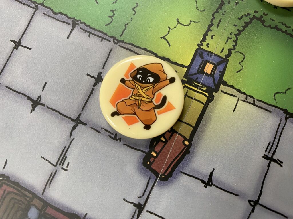Ein Spielermarker mit einer Ninja-Katze auf dem Spielplan.