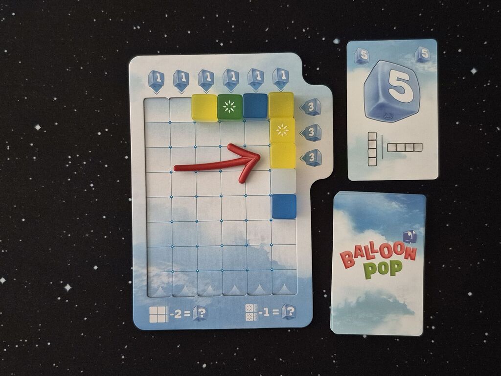 Ein Pfeil zeigt auf Würfel auf dem Spielertableau.