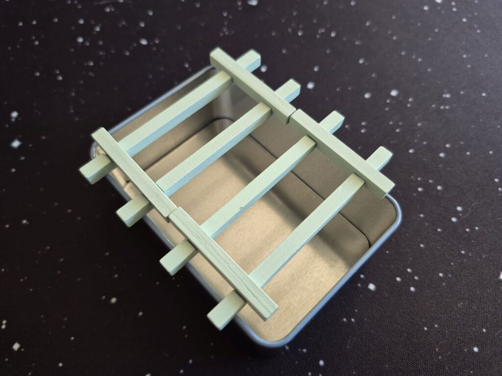 Eine Dose mit zwei Holzgittern.