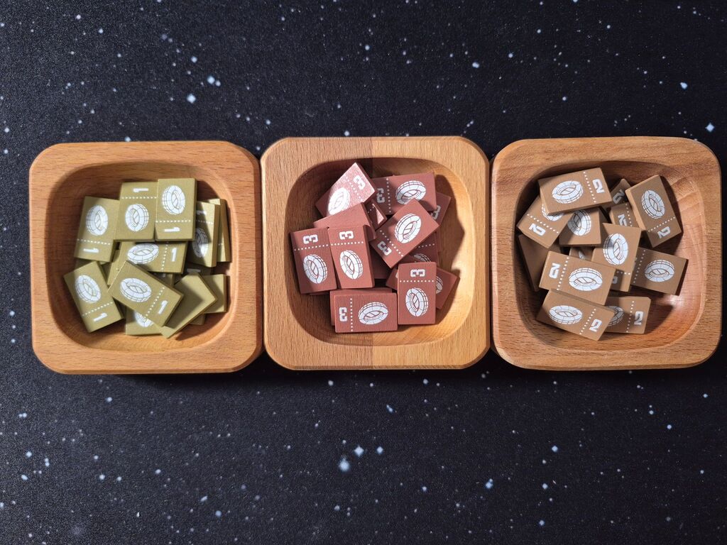 Drei Holzschalen mit Markern mit Zahl und Symbol.