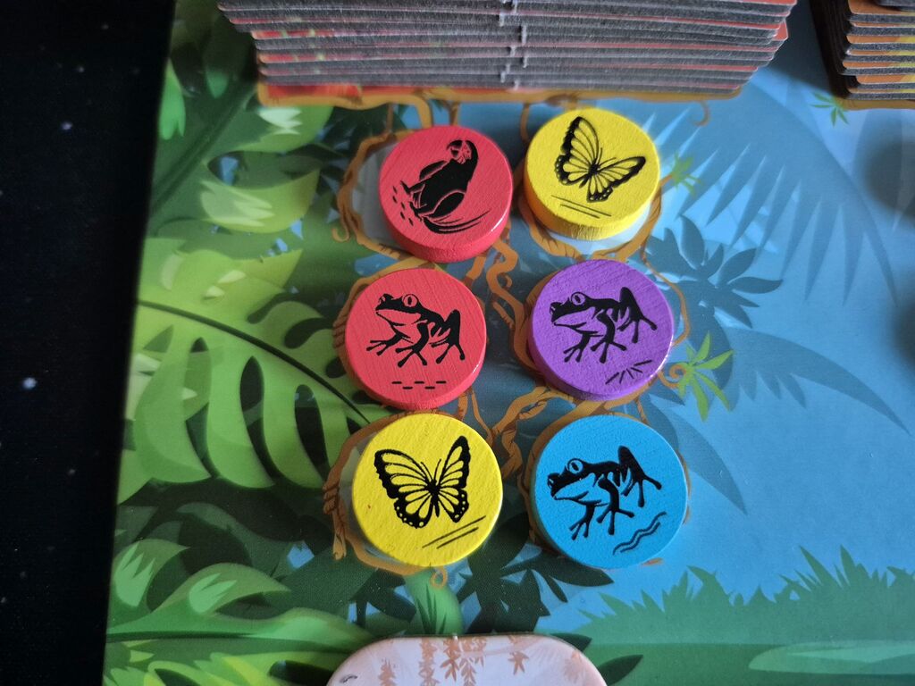 Sechs Marker mit Tieren in vier Farben auf dem Auslagetableau von "Rainforest".