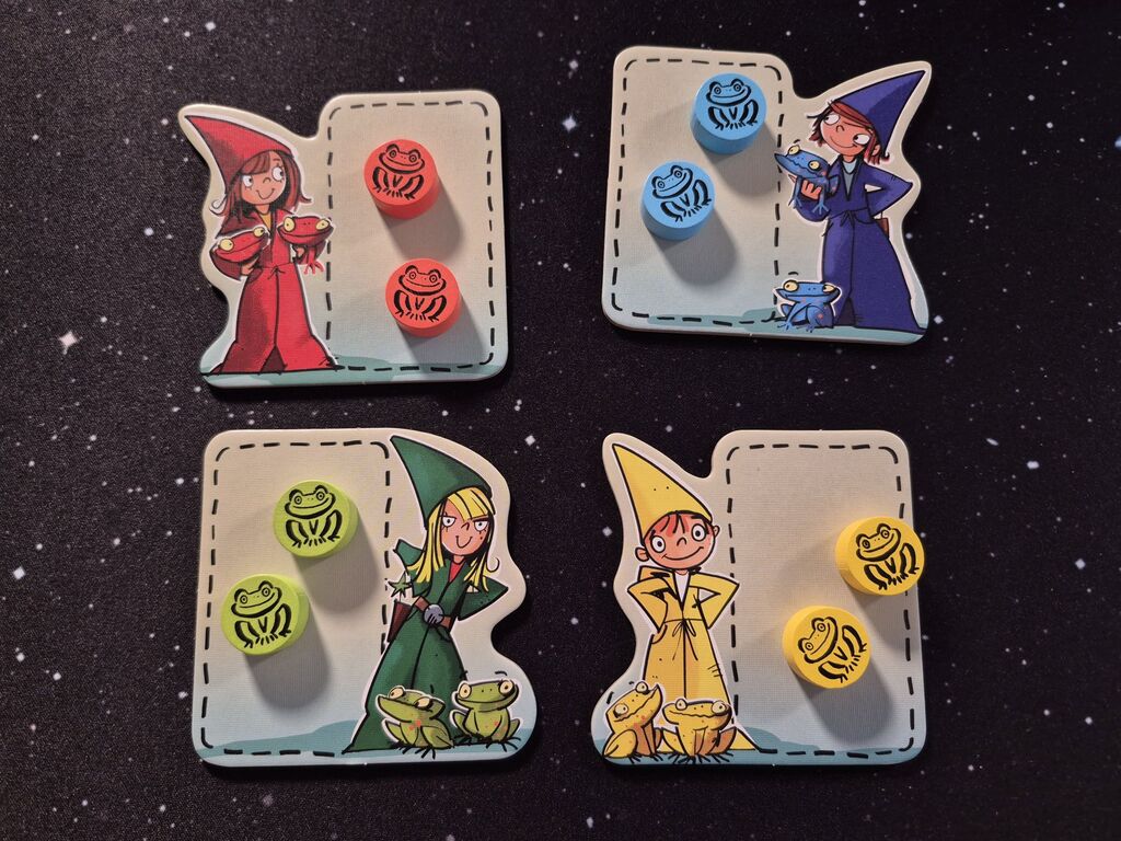 Vier Plättchen mit einem Zauberer oder Zauberin mit Fröschen und Froschmarkern.