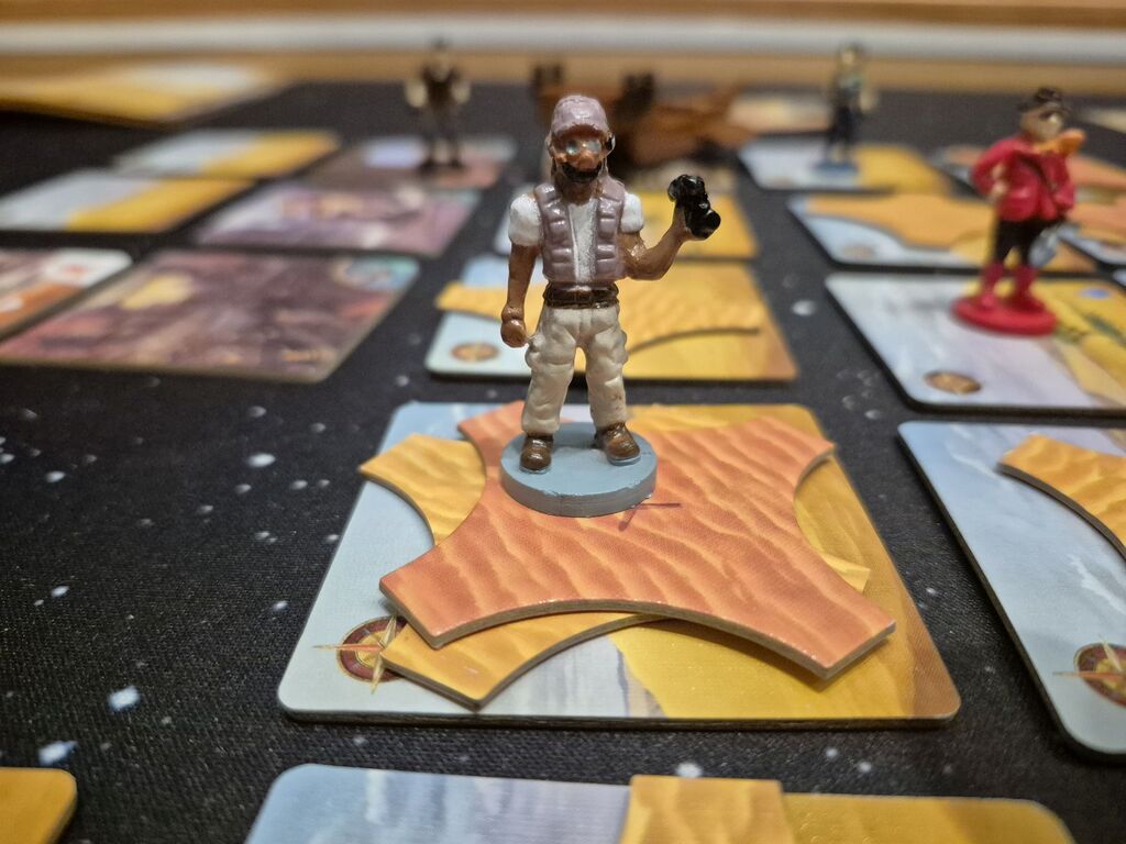 Spielfiguren auf Wüstenfeldern mit Sandplättchen.