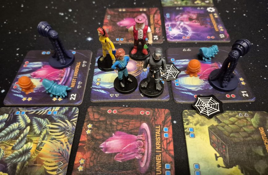 Vier Spielfiguren auf einem Feld, drumherum weitere Figuren und Marker.